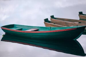 wooden boats moored on calm pond water